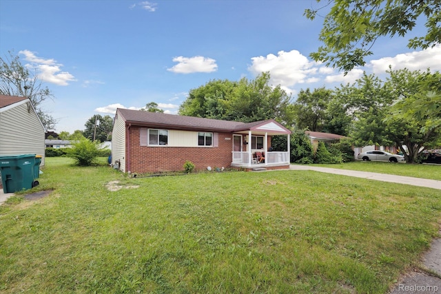 15447 Taft St, Westland, MI 48174 - view of front of house with brick siding, a front yard, and covered porch