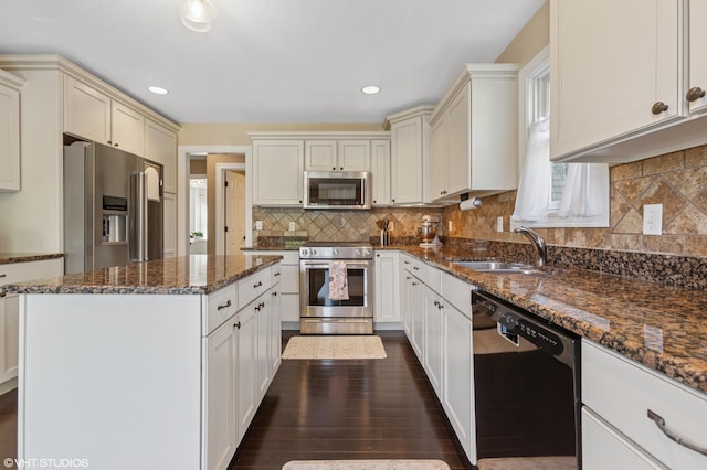 6044 Wabash Ln, Stevensville, MI 49127 - kitchen with appliances with stainless steel finishes, dark stone countertops, a kitchen island, dark wood-type flooring, and tasteful backsplash