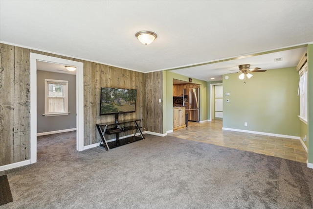 3049 Kooi St, Muskegon, MI 49444 - unfurnished living room with light carpet, ceiling fan, wooden walls, and ornamental molding