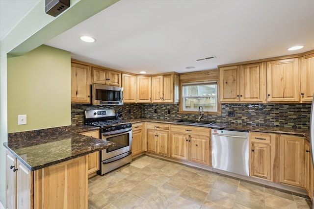 3049 Kooi St, Muskegon, MI 49444 - kitchen featuring appliances with stainless steel finishes, dark stone countertops, tasteful backsplash, light brown cabinets, and recessed lighting
