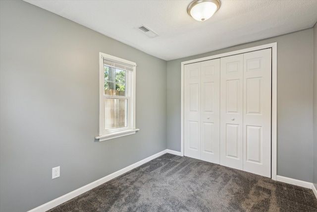 3049 Kooi St, Muskegon, MI 49444 - unfurnished bedroom featuring dark colored carpet and a closet