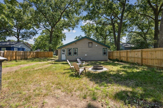 3049 Kooi St, Muskegon, MI 49444 - back of house featuring an outdoor fire pit, a fenced backyard, and log veneer siding