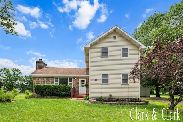 139 W Grand Ledge Hwy, Sunfield, MI 48890 - rear view of property featuring a yard, a chimney, and brick siding
