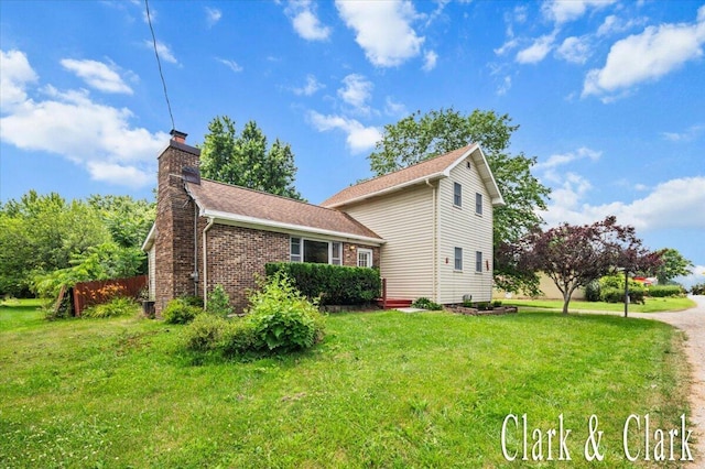 139 W Grand Ledge Hwy, Sunfield, MI 48890 - view of home's exterior featuring a chimney, a lawn, and brick siding