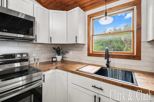 139 W Grand Ledge Hwy, Sunfield, MI 48890 - kitchen with appliances with stainless steel finishes, butcher block countertops, backsplash, white cabinetry, and wooden ceiling