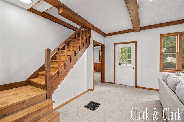 139 W Grand Ledge Hwy, Sunfield, MI 48890 - unfurnished living room featuring carpet, beam ceiling, and stairway