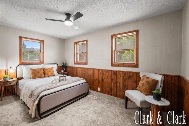 139 W Grand Ledge Hwy, Sunfield, MI 48890 - bedroom featuring multiple windows, wooden walls, a wainscoted wall, carpet flooring, and a textured ceiling