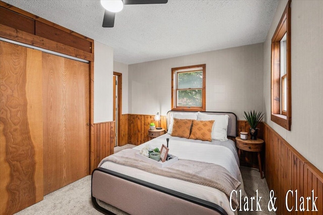 139 W Grand Ledge Hwy, Sunfield, MI 48890 - bedroom featuring carpet floors, wood walls, a wainscoted wall, a textured ceiling, and a closet