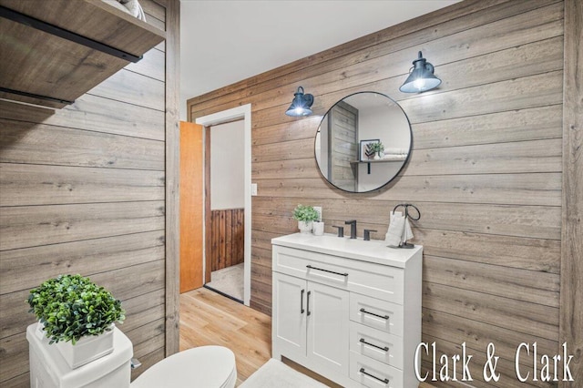 139 W Grand Ledge Hwy, Sunfield, MI 48890 - half bathroom featuring wood walls, vanity, and wood finished floors