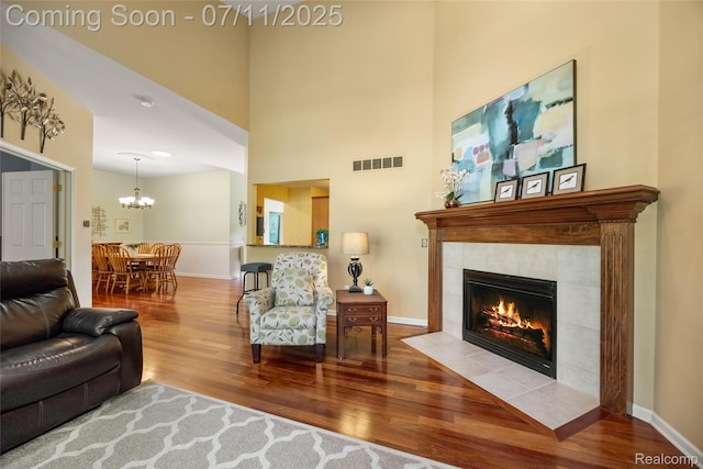 52221 Giuliano Ln, Macomb, MI 48042 - living room featuring wood finished floors, a tile fireplace, a chandelier, and a towering ceiling
