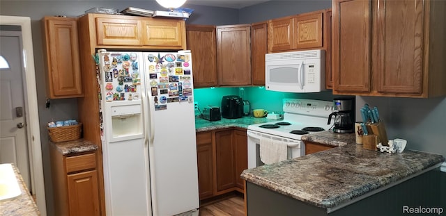 507 Main St, Fenton, MI 48430 - kitchen with white appliances, a peninsula, stone countertops, light wood-style floors, and brown cabinets