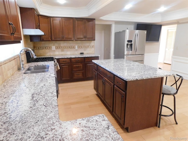 2238 Nadine Dr, Sterling Heights, MI 48310 - kitchen with stainless steel appliances, a tray ceiling, exhaust hood, ornamental molding, and a kitchen breakfast bar