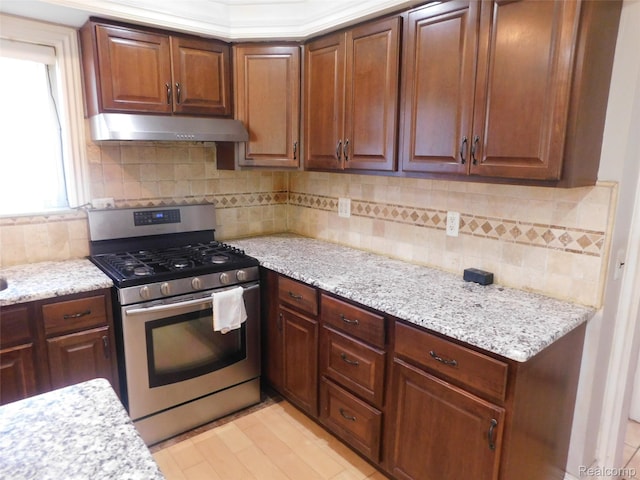 2238 Nadine Dr, Sterling Heights, MI 48310 - kitchen featuring gas range, under cabinet range hood, backsplash, light stone counters, and light wood-type flooring