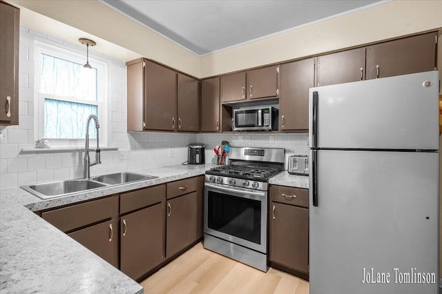 2958 Bluewater Ln SW, Grandville, MI 49418 - kitchen featuring stainless steel appliances, tasteful backsplash, light countertops, and light wood-type flooring