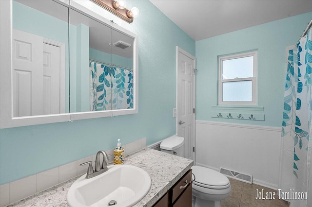 2958 Bluewater Ln SW, Grandville, MI 49418 - full bathroom with vanity, a wainscoted wall, a shower with curtain, and tile patterned floors