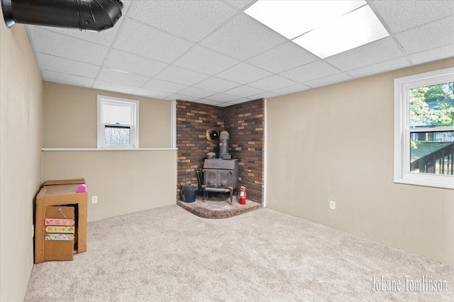 2958 Bluewater Ln SW, Grandville, MI 49418 - basement with a wood stove, carpet flooring, plenty of natural light, and a paneled ceiling