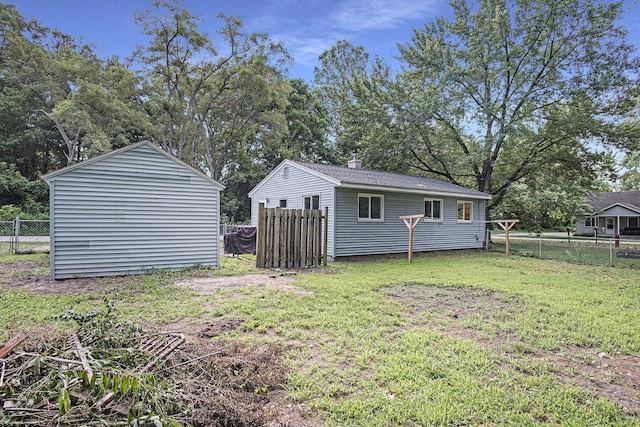 165 Kenton St SE, Grand Rapids, MI 49548 - fenced backyard featuring an outbuilding and view of wooded area