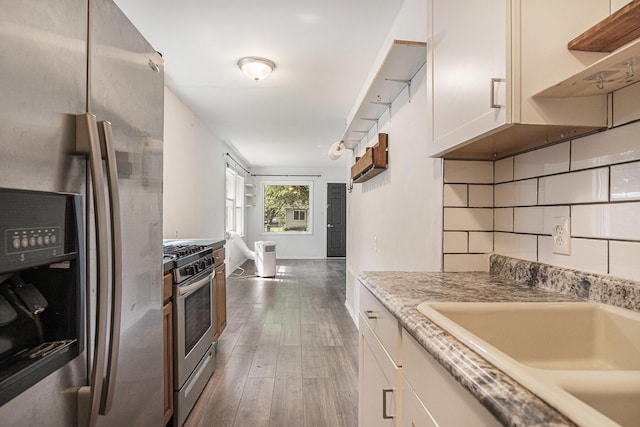 165 Kenton St SE, Grand Rapids, MI 49548 - kitchen with appliances with stainless steel finishes, white cabinets, wood-type flooring, open shelves, and light stone countertops