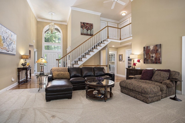 106 Kingsbury Ct, Battle Creek, MI 49015 - carpeted living area featuring a towering ceiling, stairway, a ceiling fan, crown molding, and a chandelier