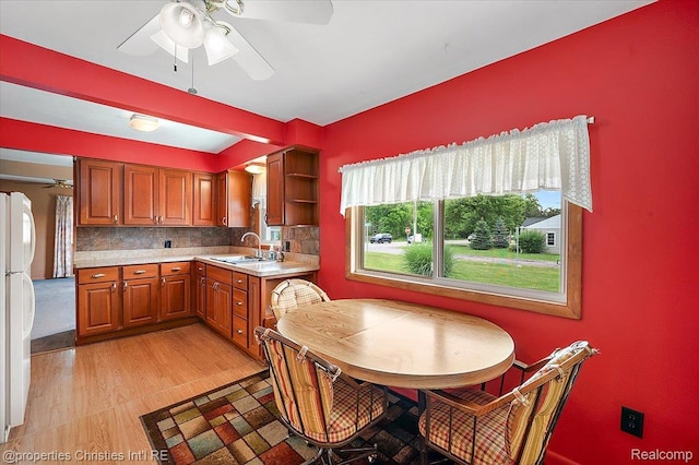 4681 Cass Elizabeth Rd, Waterford, MI 48327 - kitchen with ceiling fan, light countertops, brown cabinets, tasteful backsplash, and freestanding refrigerator