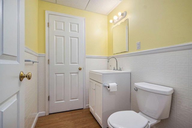5625 Bay Meadow Trl, Portage, MI 49024 - half bath with tile walls, wainscoting, vanity, and wood finished floors