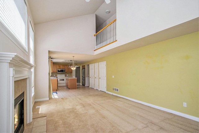 5625 Bay Meadow Trl, Portage, MI 49024 - unfurnished living room featuring a high ceiling, light colored carpet, and a tile fireplace