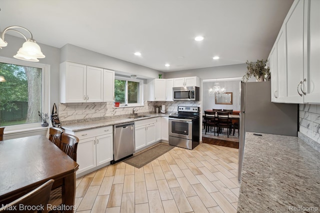 6810 Killarney Dr, Troy, MI 48098 - kitchen featuring stainless steel appliances, decorative backsplash, white cabinets, light stone counters, and recessed lighting