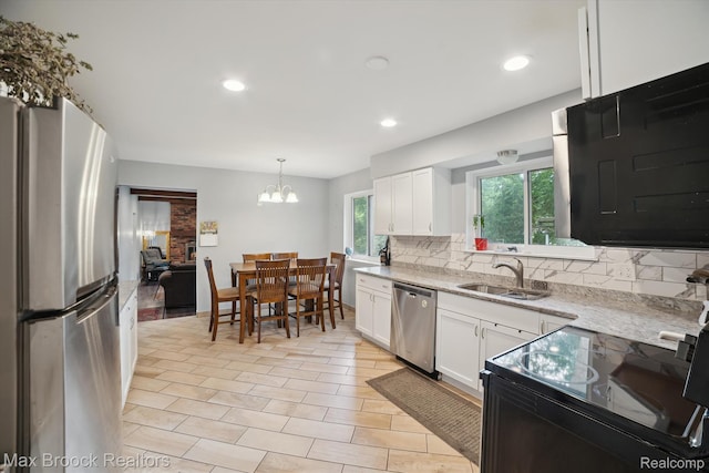 6810 Killarney Dr, Troy, MI 48098 - kitchen featuring appliances with stainless steel finishes, backsplash, white cabinetry, a chandelier, and pendant lighting