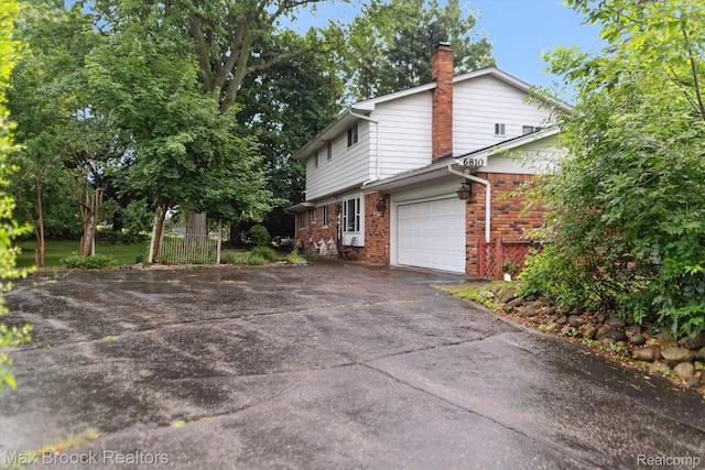 6810 Killarney Dr, Troy, MI 48098 - view of side of property with driveway, brick siding, a chimney, and an attached garage