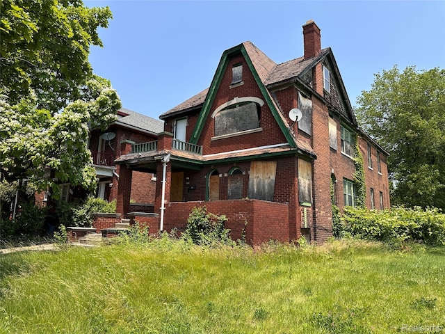 3962 Helen St, Detroit, MI 48207 - rear view of house featuring brick siding, a chimney, and a balcony
