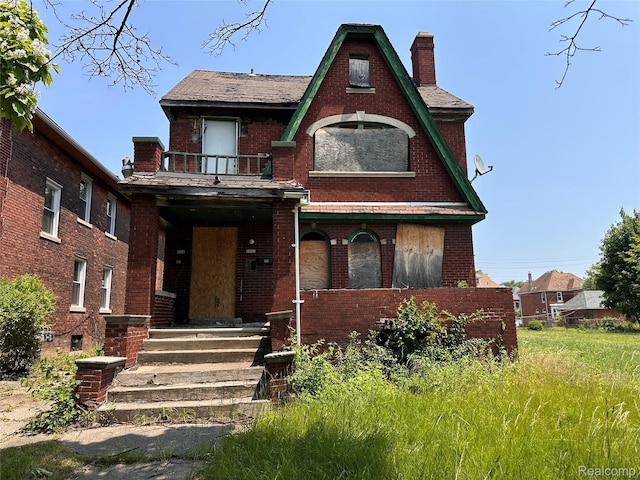 3962 Helen St, Detroit, MI 48207 - tudor house with a balcony, brick siding, and a chimney