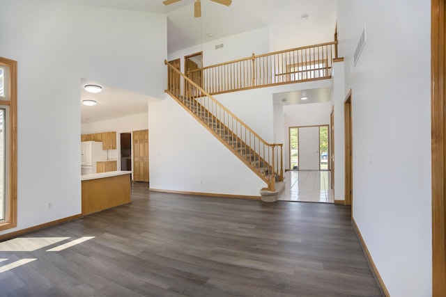 4213 Silverleaf Dr, Ypsilanti, MI 48197 - unfurnished living room featuring a towering ceiling, stairs, wood finished floors, and ceiling fan