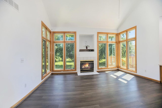4213 Silverleaf Dr, Ypsilanti, MI 48197 - unfurnished living room with plenty of natural light, dark wood-style flooring, a tiled fireplace, and high vaulted ceiling