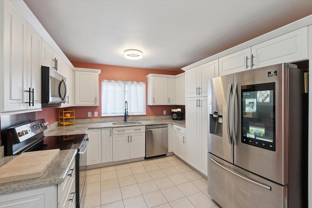 910 Newport Dr, Fenton, MI 48430 - kitchen with appliances with stainless steel finishes, white cabinetry, light tile patterned floors, and light stone counters