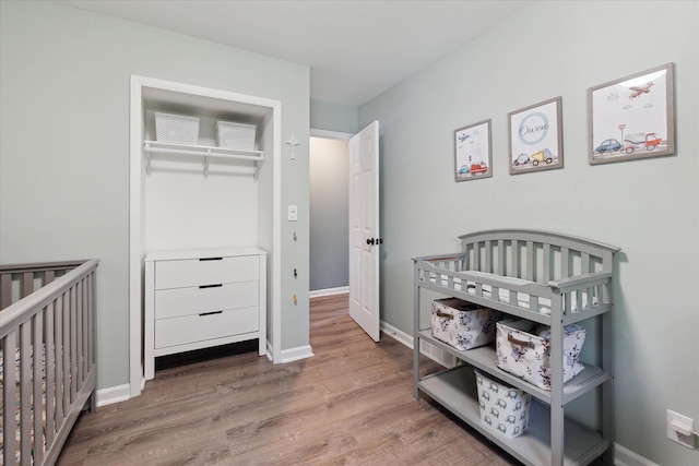 910 Newport Dr, Fenton, MI 48430 - bedroom featuring wood finished floors, a closet, and a nursery area