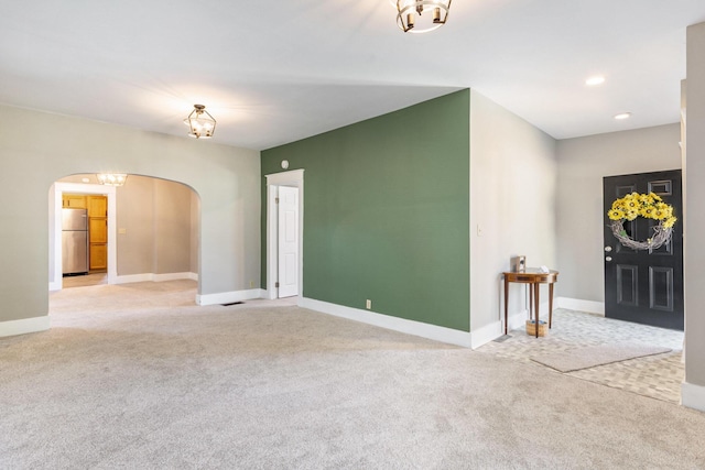 947 Pearl St, Benton Harbor, MI 49022 - entryway with arched walkways, light colored carpet, a chandelier, and recessed lighting