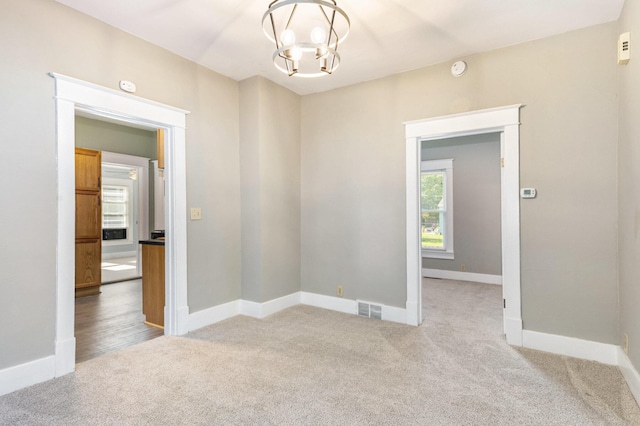 947 Pearl St, Benton Harbor, MI 49022 - empty room with light carpet, a chandelier, and a smoke detector