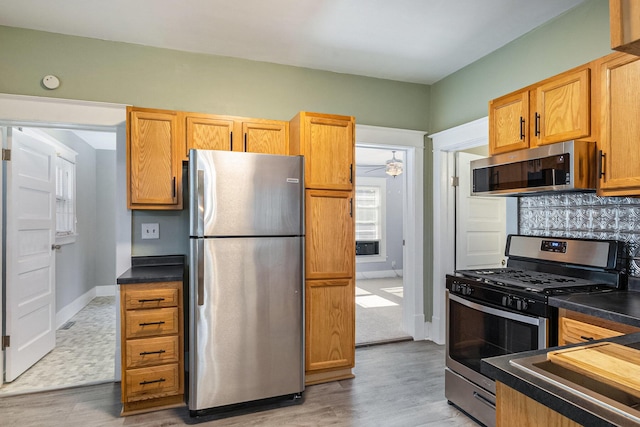 947 Pearl St, Benton Harbor, MI 49022 - kitchen featuring appliances with stainless steel finishes, dark countertops, backsplash, and light wood-style flooring
