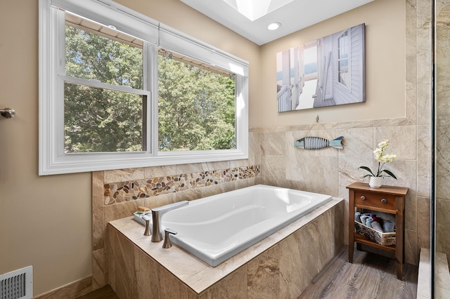 6794 Brickleton Ct, Portage, MI 49024 - bathroom featuring a garden tub and wood finished floors