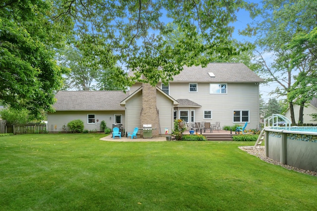 6794 Brickleton Ct, Portage, MI 49024 - back of property featuring a deck, an outdoor pool, a shingled roof, and a chimney