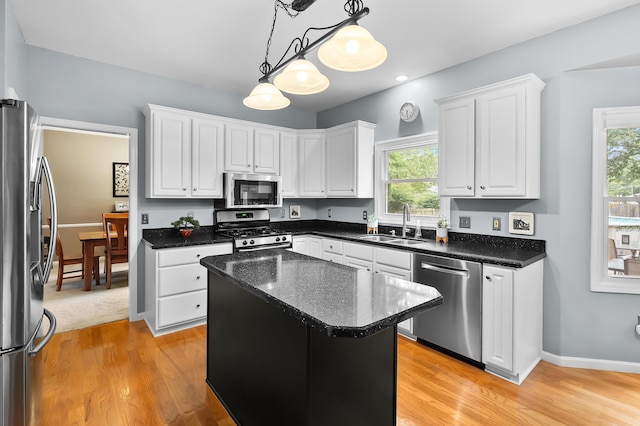 6794 Brickleton Ct, Portage, MI 49024 - kitchen with stainless steel appliances, white cabinets, light wood-style flooring, decorative light fixtures, and a kitchen island