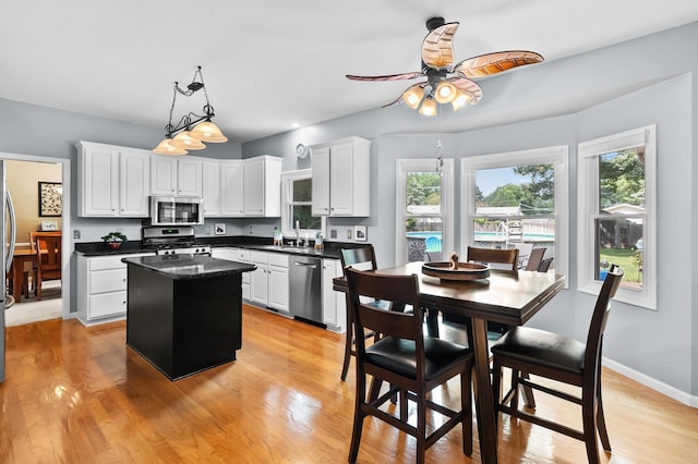 6794 Brickleton Ct, Portage, MI 49024 - kitchen with appliances with stainless steel finishes, a kitchen island, a ceiling fan, dark countertops, and white cabinets