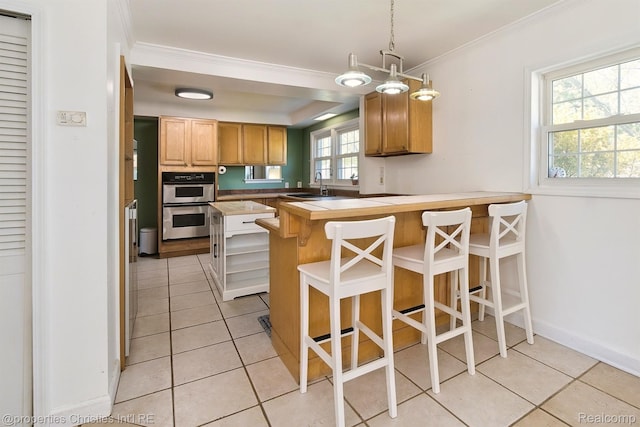 30160 Marshall St, Southfield, MI 48076 - kitchen with stainless steel double oven, a peninsula, light tile patterned floors, ornamental molding, and a kitchen breakfast bar