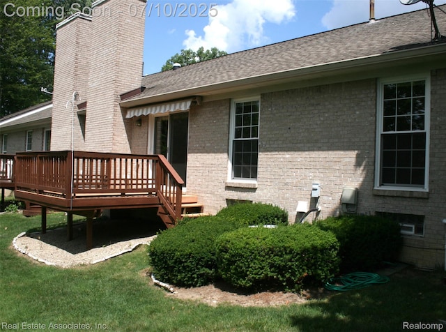 41503 Haggerty Woods Ct Unit 35, Canton, MI 48187 - rear view of property with a chimney, brick siding, a deck, a lawn, and a shingled roof
