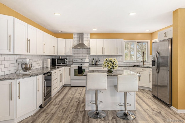 5103 Coachlight Dr, Fenton, MI 48430 - kitchen with stainless steel appliances, wall chimney exhaust hood, beverage cooler, white cabinets, and tasteful backsplash