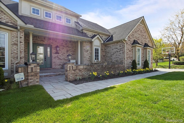900 Mcdonald Dr, Northville, MI 48167 - view of front facade with a front yard, brick siding, a shingled roof, and covered porch
