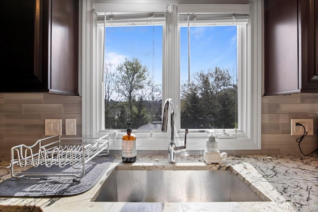 900 Mcdonald Dr, Northville, MI 48167 - kitchen view of tasteful backsplash, dark brown cabinets, and light stone counters