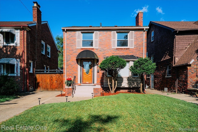 16219 Normandy St, Detroit, MI 48221 - traditional-style house featuring brick siding, a front yard, and a chimney
