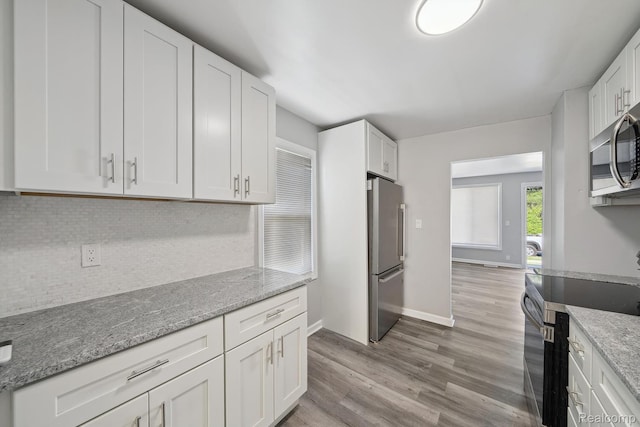 2245 Spring Hill Ave, Inkster, MI 48141 - kitchen featuring stainless steel appliances, white cabinets, light wood-type flooring, and tasteful backsplash