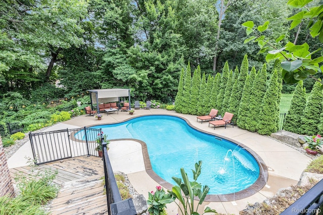 9780 Oak Valley Dr, Clarkston, MI 48348 - outdoor pool featuring a wooden deck, view of wooded area, and a patio area